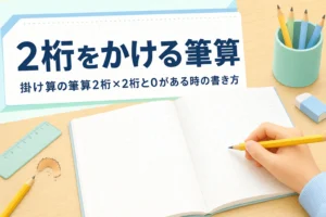 机の上の方眼ノートと鉛筆を持つ子どもの手元と、2桁×2桁の掛け算の筆算を紹介する記事タイトル